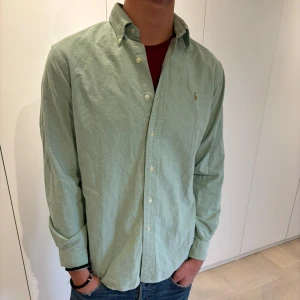 Ralph Lauren skjorta  - Otroligt chill grön skjorta ifrån Ralph Lauren vars färg passar fint till det kalla vädret.                              Finns en defekt som visas i bilden.                              Classic fit.                                                                        Pris kan diskuteras!