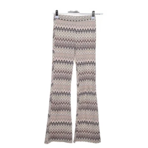 Mönstrade bootcut byxor från kappahl. - Snygga bootcut byxor med zigzag-mönster i beige, rosa och bruna toner. Byxorna har hög midja och är tillverkade i ett mjukt material som ger en skön passform. Perfekta för dig som vill sticka ut med coola mönster och retrovibbar!! Byxorna har ett litet hål. Är storlek 146 men jag skulle säga att dom passar folk med storlek 152-158 också.