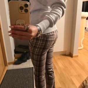 vintage byxor🤎🩷 - Snygga brun,beige och rosa rutiga byxor från Tommy Hilfiger. Byxorna är flare men det märks inte så mycket, de är också low waisted. Är nya och inte använda! Passar bra för den som är 157 ich 🥲