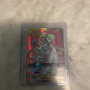 Pokémon Gardevoir & Sylveon GX Tag Team - Cool och glittrande Pokémon-kort med Gardevoir & Sylveon i Tag Team GX-version! Perfekt för samlare och spelare som vill boosta sin lek med kraftfulla attacker och snygg design. Kortet är i skyddande plastfodral och har färgstark holografisk yta.