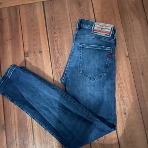 Diesel D-Strukt jeans blå stl 29/32 - Snygga blå jeans från Diesel, modell D-Strukt. Jeansen har en mörkblå tvätt och är tillverkade i slitstarkt denim. Passar dig som gillar en stilren look med coola detaljer.