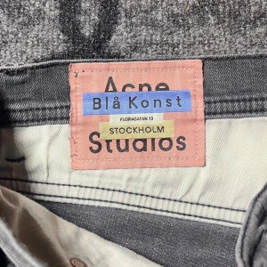 Grå Acne Studios Blå Konst jeans 31/32 - Snygga grå jeans från Acne Studios Blå Konst med klassisk femficksdesign och knäppning fram. Jeansen har raka ben och diskret tvättad look. Perfekta för dig som gillar stilrena och trendiga byxor med svensk design.