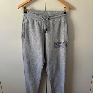 Grå mjukisbyxor från Hoodrich XS - Grå mjukisbyxor från Hoodrich i storlek XS. Byxorna har snörning i midjan, sidofickor och en bakficka. Hoodrich-logga tryckt på ena benet. Sköna och stilrena, perfekta för chill eller träning.          Köp både hoddie och byxor och få ett bättre pris 😊