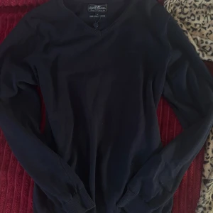 Marinblå  tröja från Hampton Republic - Marinblå långärmad tröja från Hampton Republic med v-ringad hals och ribbade muddar. Tillverkad i mjuk bomull som känns skön mot huden. Perfekt för dig som gillar en klassisk och stilren look.