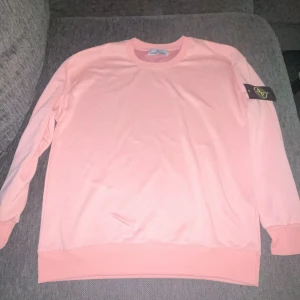 Ljusrosa Stone Island sweatshirt - Säljer en ljusrosa sweatshirt från Stone Island med klassisk logga på armen. Helt ny aldrig använd.