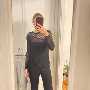 Svart stickad meshtröja med asymmetri - Svart långärmad stickad topp med meshmönster och asymmetrisk nederkant från Zara i strl S