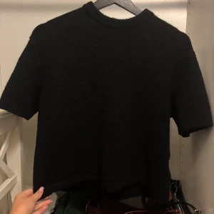 Svart stickad tröja från Gina Tricot - En svart stickad tröja från Gina Tricot med korta ärmar och rund halsringning. Använd fåtal gånger!