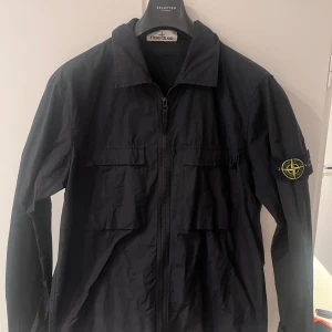 Svart overshirt från Stone Island - Svart overshirt från Stone Island. Skicket är väldigt bra och inga skavanker finns. Perfekt nu till hösten!
