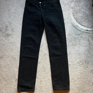 Svarta straight jeans från Karve W28 - Svarta jeans från Karve i modellen Straight Black Stone. Klassisk femficksdesign, raka ben och normal passform. Tillverkade av 100% återvunnen bomull för en schysst vibe. Perfekta om du gillar stilrena och enkla svarta jeans.