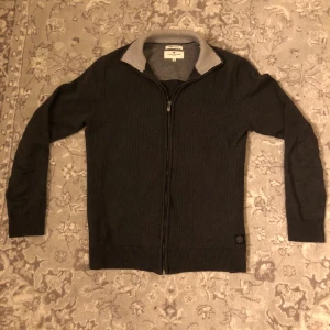 Grå Fullzip från Tom Tailor - Säljer nu denna grå fullzip från Tom Tailer| den är i väldigt bra skick och är knappt använd| Storlek M men passar mer som S| Skriv vid några frågor eller funderingar!