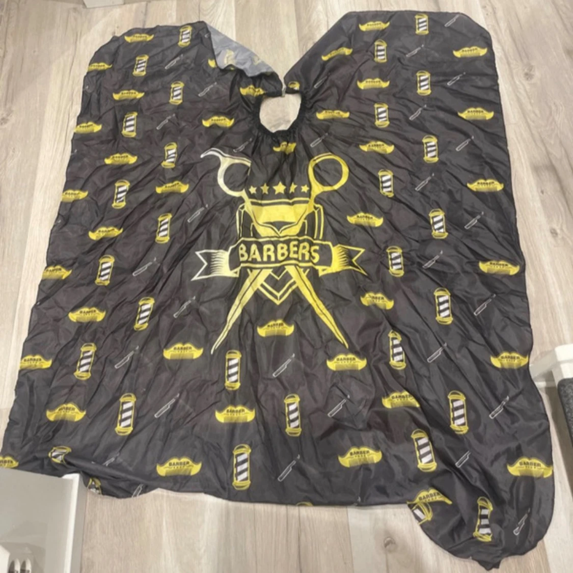 Svart barberarkappa med gul print
