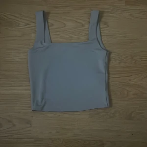 Ljusgrå linnetopp från Amisu - Säljer en stilren ljusgrå linnetopp från Amisu i storlek XS. Toppen har breda axelband och rak halsringning, perfekt för en enkel och clean look. Materialet känns mjukt och stretchigt, vilket gör den bekväm att bära hela dagen.