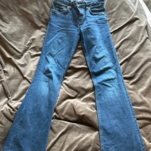 Blå bootcut jeans från Zara, strl 36 - Snygga blå bootcut jeans från Zara i storlek 36. Klassisk femficksmodell med normal passform och medelhög midja. Jeansen är tillverkade i mjukt denimtyg och har en stilren look med ljusblå tvätt och kontrastsömmar.