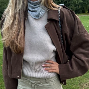 Zara mockajacka  - Säljer en brun mockajacka med oversized passform och dragkedja framtill. Jackan har klassisk krage, långa ärmar och axelklaffar för en cool look. Perfekt att slänga över en t-shirt eller hoodie för en chill vibe.