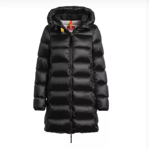 Svart lång dunjacka från Parajumpers - Säljer en svart lång dunjacka från Parajumpers, modell Marion. Jackan har huva, dragkedja framtill och quiltad design. Perfekt för kalla dagar och riktigt snygg med sin blanka finish och klassiska look.