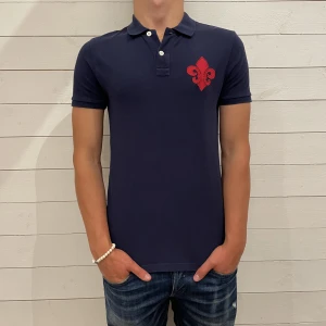 Morris piké  - Piké från Morris - Logotyp vid vänster bröst samt ryggen - Storlek : S - Pikén är i fint skick utan defekter - Vårat pris : 249 sek - Nypris : 999 sek - Modellen på bilden är 180 CM och väger 75 KG