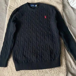 Ralph lauren tröja - Kabelstickad svart tröja från Ralph Lauren . Inte alls mycket använd så fint skick förutom litet hål.