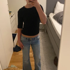 Svart topp med trekvartsärm från H&M - En enkel och stilren svart topp från H&M med trekvartsärm och rund halsringning. Modellen är figurnära och passar perfekt till jeans eller kjol. Gjord i mjukt bomullsmaterial som är skönt mot huden.