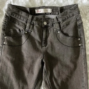 Grå slim fit jeans från Pecan - Snygga grå jeans från Pecan i slim fit-modell med klassiska fem fickor och kontrastsömmar. Jeansen har normal midja och raka ben, tillverkade i mjukt denimtyg som sitter skönt hela dagen.