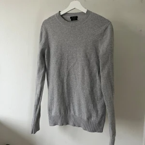 Grå ulltröja från Massimo Dutti - Snygg grå tröja från Massimo Dutti i ren ull. Klassisk rund halsringning och ribbade muddar vid ärmslut och nederkant. Perfekt för lager-på-lager och enkel att matcha med allt. Stilren och tidlös design som funkar året runt.