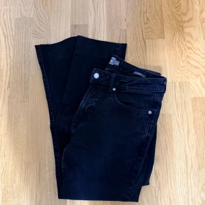 Svarta slim fit jeans från Dressmann - Svarta jeans från Dressmann i slim fit-modell. Klassisk femficksdesign med dragkedjegylf och bälteshällor. Jeansen är tillverkade i ett stretchigt bomullsmaterial som ger en snygg och bekväm passform.