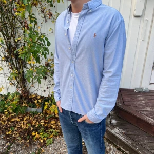 Ljus blå raulph lauren skjorta - Tja, säljer en super snygg raulph lauren skjort i färgen ljusblå. Den är i storlek L men passar även XL. Den är i slim fit men passar även regular fit. Den har en lite defekt bakom högra axeln men är inget farligt. Skriv vid frågor eller funderingar🙌🤝 fraktar inom 24h📬