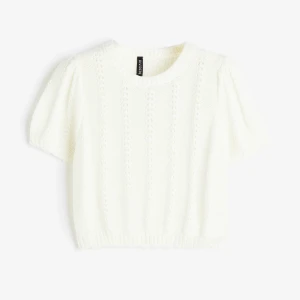 Vit stickad kortärmad tröja hm - Superfin vit stickad tröja från hm med korta puffärmar och rund hals. Tröjan har ett snyggt hålmönster och ribbade kanter nertill och vid ärmsluten. Köpte begagnat men har själv använt den 1 gång!