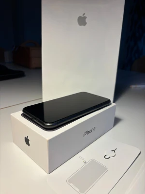 iPhone 11 - Snygg svart iPhone 11 med originalkartong och tillbehör. Batterihälsa på 74%. Telefonen är i gott skick med minimalt synligt slitage. Dubbelkamera för fantastiska bilder och Face ID. Perfekt för dig som vill ha en pålitlig och stilren mobil. Laddare medföljer ej