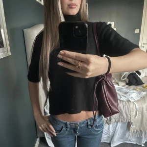 Fin polotröja  - Svart polotröja från Stories i storlek M men passar som S/XS. Tröjan är stickad med en hög krage och har en croppad passform som visar midjan. Ärmarna är trekvarts och sitter väldigt fint. Tar gärna emot prisförslag 💗