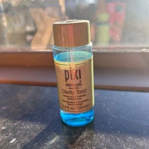 Pixi Clarity Tonic toner 100 ml - Pixi Clarity Tonic är en ansikts-toner med salicylsyra och probiotika som hjälper till att klargöra huden. Kommer i en genomskinlig plastflaska med ljusgrönt lock och blå vätska. Perfekt för dig som vill ha en fräsch och ren känsla i ansiktet. Lite använd.