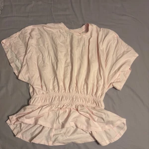 Tshirt med fokus på midjan - En rosa tshirt från Lager157 som är tajtare runt midjan. Den är i storlek S. Använd en gång så inga märken på den.