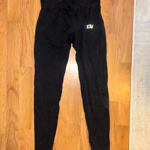 Svarta leggings från ICANIWILL - Svarta leggings från ICANIWILL med logga på höften. De har en tight passform och är gjorda i ett stretchigt syntetmaterial som sitter skönt mot kroppen. Perfekta för träning eller chill. Snyggt minimalistisk design.