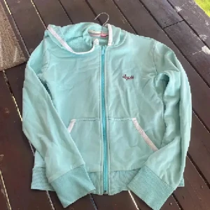 Vintage Ljusblå hoodiejacka från Esprit - Snygg ljusblå hoodiejacka från Esprit med dragkedja och två fickor fram. Jackan har ribbade muddar, vit kant på huvan och broderad logga på bröstet. Materialet är mjukt och känns som frotté, perfekt för chill dagar. Vintage💕