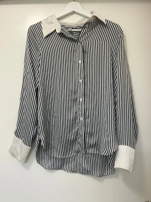 Randig skjorta från H&M i S - Randig svart/vit skjorta från H&M i storlek S, silkigt tyg