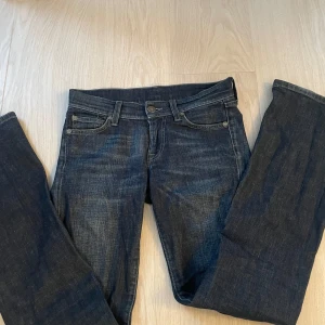 Mörkblå bootcut jeans från 7 For All Mankind - Jättesnygga lågmidjade mörkblå jeans från 7 For All Mankind. Bootcut-modell med normal passform