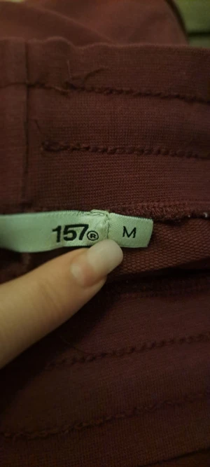 Vinröda mjukisbyxor från 157, storlek M - Säljer ett par vinröda mjukisbyxor från 157 i storlek M. Byxorna har rak passform, snörning i midjan och är tillverkade i mjukt bomullsmaterial. Perfekta för chill dagar och har en enkel, clean look med breda ben.