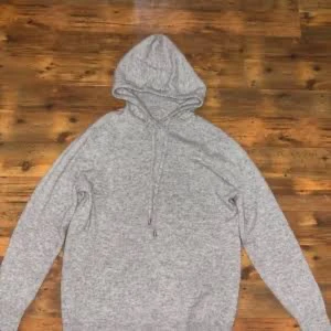 Merino/Cashmere hoodie grå - Säljer en enkel och stilren grå hoodie med huva och snörning. Tröjan har långärmade ärmar och är tillverkad i mjukt material som passar perfekt för chill dagar. Klassisk passform och neutral färg gör den lätt att matcha med allt.