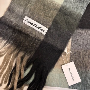 Halsduk från Acne Studios - Mjuk och fluffig halsduk från Acne Studios i rutigt mönster i färg av grått, grönt, svart och beige. Pris kan diskuteras😊