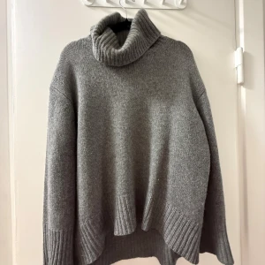 Grå polotröja i kashmir från Notshy - Supermjuk och oversized grå polotröja från Notshy i lyxig kashmir. Tröjan har bred ribbstickad polokrage, långa ärmar och ribbade muddar. Mitt favoritplagg i garderoben!! Sååå snygg!!! Köpte för 4999 i valdisere 