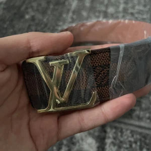 Brunt rutigt bälte med guld buckla - Helt nytt bälte i brunt med guldig buckla, ej riktig men perfekt tillägg till outfits. Kom dm för frågor👍🏼