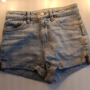 Ljusblå jeansshorts från LAB Industries - Snygga ljusblå jeansshorts från LAB Industries med klassisk femficksdesign och uppvikta benslut. Shortsen har hög midja och är perfekta för varma dagar. Tidlös denimlook med detaljer i kontrastsömmar och bälteshällor.