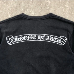Chrome Hearts Scroll Logo T-Shirt - Chrome Hearts Scroll Logo T-Shirt Black Size Small Condition: Used. Some fading and discolouring throughout. See pics. Price is negotiable, legit checked by reddit!  Measurements (in CM) Chest: 44 Length: 64 Shoulders: 41 Sleeve Length: 19 Hem: 45