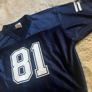 Blå NFL Owens #81 tröja XL - Marinblå NFL tröja med Owens och nummer 81 tryckt i vitt på både fram- och baksida. V-ringning och korta ärmar. 