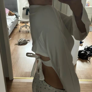 Vit topp med knyt i ryggen💕 - Säljer en vit med långa ärmar och snygg knytning i ryggen. Toppen har en croppad passform och är tillverkad i mjukt bomullsmaterial. Ärmarna är lätt utsvängda. Den är endast använd 2 gånger 💕 tröjan har ett pytte liten håll vid halsen som man inte alls ser, den var så när jag fick den