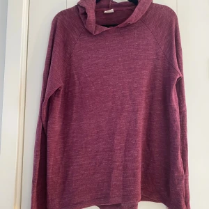 Vinröd hoodie från Gina Tricot - Mysig vinröd hoodie från Gina Tricot i mjukt, stickat material. Tröjan har huva, långa ärmar och en avslappnad passform. Perfekt för chill dagar eller när du vill vara extra bekväm. Mått Över bröstet: ca 51 cm Längd från axeln och ner: ca 67 cm  50% viskos, 25% polyester, 20% bomull och 5% elastan  Kommer från ett djur och rökfritt hem.