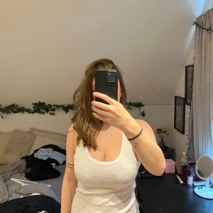 Vit ribbad linnetopp från lager 157 - Säljer en vit ribbad linnetopp från lager 157 med rundad halsringning och breda axelband. Toppen är ärmlös och har en slim passform som sitter snyggt mot kroppen. 