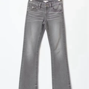 Grå bootcut jeans med utsvängda ben - Snygga grå jeans med bootcut-modell och utsvängda ben. Jeansen har klassisk femficksdesign, bälteshällor och dragkedjegylf. Perfekta för dig som gillar en retroinspirerad look och vill ha ett par jeans som sticker ut.