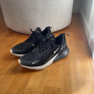 Nike Air Max 270  - Svarta Nike Air Max 270 som säljs i befintligt skick. Använda, men fina i skicket. Litet hål framme vid tån. Storlek 41, känns som 40.