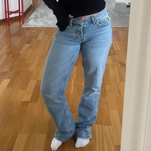  ljusblå jeans straight fit - Säljer ett par klassiska  jeans i ljusblå tvätt med rak passform och normal midja. Jeansen har fem fickor, knappgylf och är tillverkade i slitstarkt bomullsjeansmaterial. Perfekt för dig som gillar en tidlös och chill stil.
