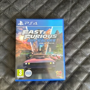 Fast & Furious Spy Racers: Rise of SH1FT3R (PS4) - Fast & Furious Spy Racers: Rise of SH1FT3R till PS4. Komplett med fodral och skiva i mycket fint skick. Spännande racingspel med co-op och online multiplayer, inspirerat av den populära serien. Perfekt för både barn och vuxna.